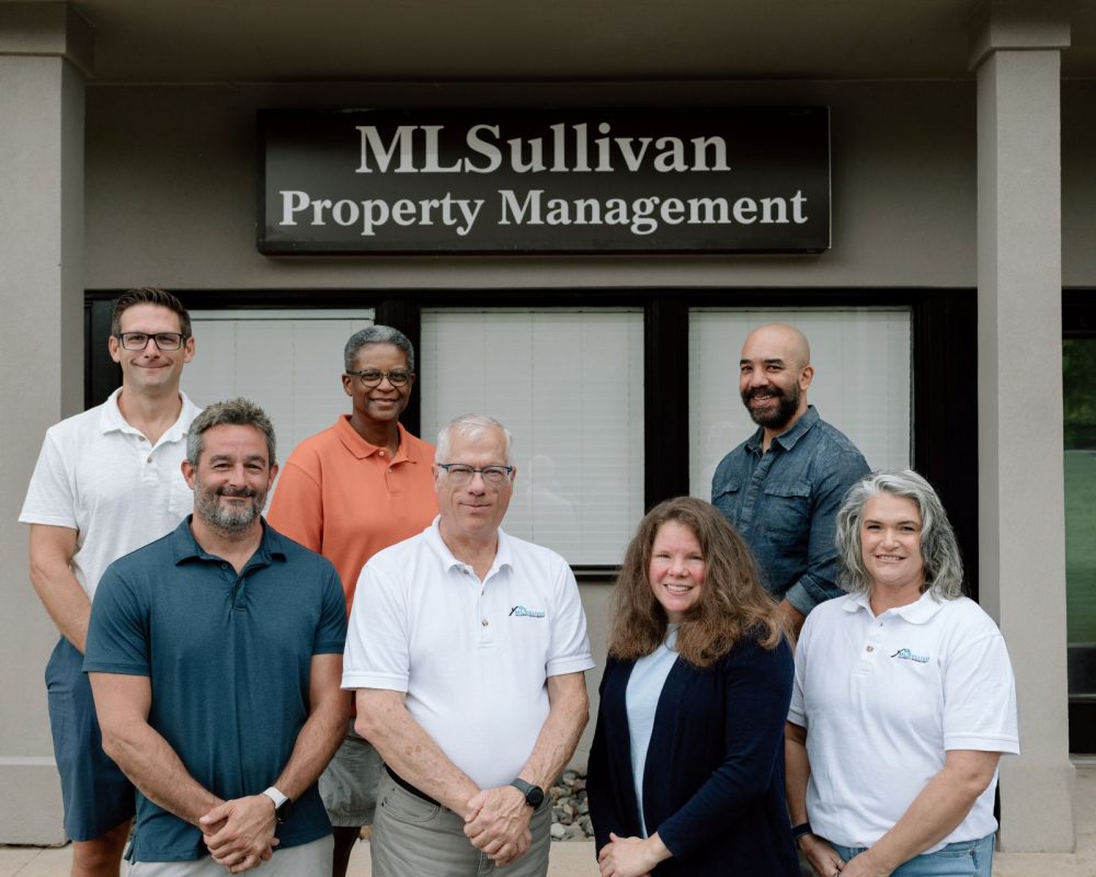 ML Sullivan Team Photo in front of Property Management Sign